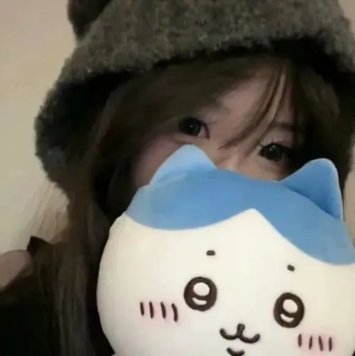 Thiếu nữ giấu mặt ngồi bàn gỗ cũ cầm ly cà phê che miệng, tóc búi cao gọn, áo blouse ren trắng tinh khôi.