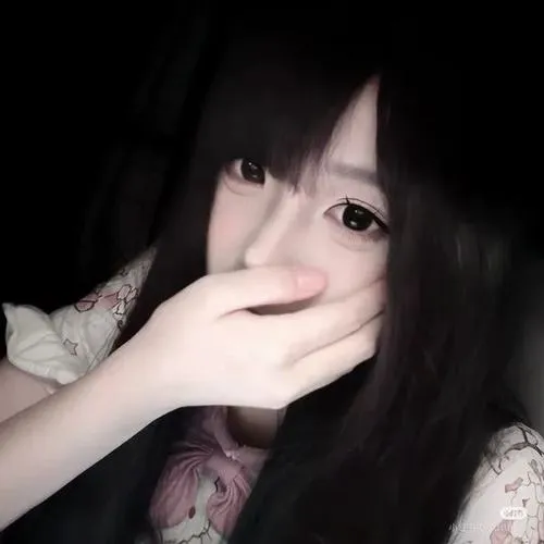 Thiếu nữ ẩn danh đứng ban công dùng cành hoa khô che miệng, tóc dài xõa vai, áo khoác denim rộng thùng thình.