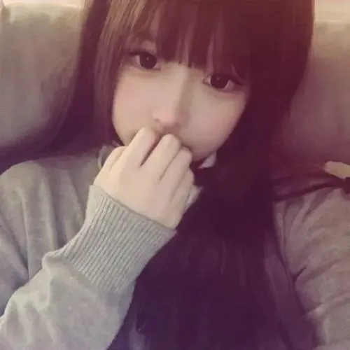 Hot girl nằm võng dùng cuốn sổ tay che miệng, tóc highlight hồng, áo tank top trắng phối shorts jeans.