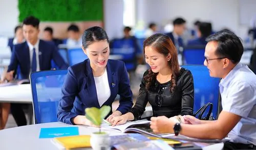 Nhóm nam nữ ngồi quanh bàn họp trao đổi tài liệu với vẻ mặt tập trung, không gian văn phòng sáng thoáng khiến bức ảnh mang rõ tinh thần văn hóa doanh nghiệp hiện đại