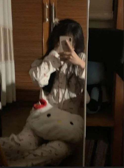 Hot girl mặc áo khoác jean rách quần short da tóc highlight ngồi trên ghế bar cầm điện thoại.