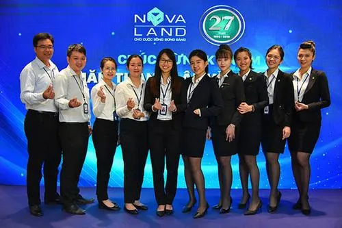 Ảnh dàn nam thanh nữ tú Nova đứng thành hàng trên sân khấu với vest tối màu lịch lãm, gương mặt tươi cười trong khung cảnh trang trọng