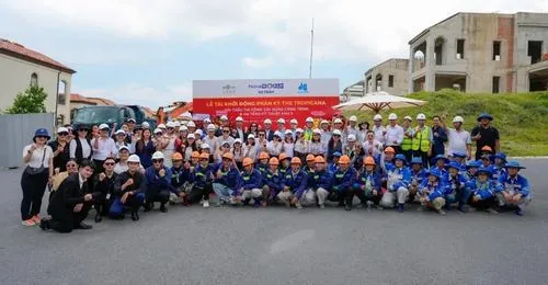 Tập thể đông người đứng chụp ngoài trời trên nền cỏ xanh rộng, áo đồng phục nổi bật giữa không gian mang cảm giác trẻ trung và phóng khoáng