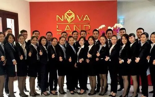 Dàn nhân sự xếp hàng đồng đều trên sân khấu ánh đèn đỏ, toàn bộ vest đen đồng bộ khiến khung hình trở nên sang trọng và nổi bật