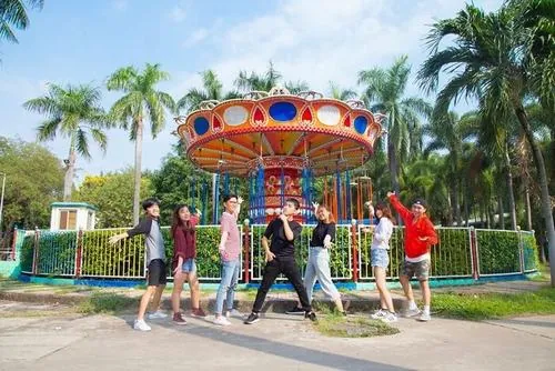 Một nhóm bạn đứng tạo dáng bên thành hồ, ánh nắng chiếu xiên làm nổi bật làn nước xanh trong phía sau