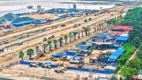 Ảnh khu đô thị lấn biển Cần Giờ cho thấy các tuyến đường nội khu chạy thẳng tắp giữa nền đất mới, xe máy công trình di chuyển liên tục tạo không khí thi công nhộn nhịp