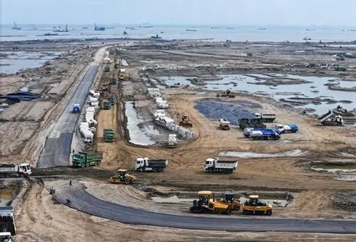 Ảnh đô thị biển Vingroup Cần Giờ ghi lại khu vực bờ biển với máy móc hoạt động dọc theo tuyến kè, màu cát vàng và nước xanh tạo tương phản khá đẹp mắt