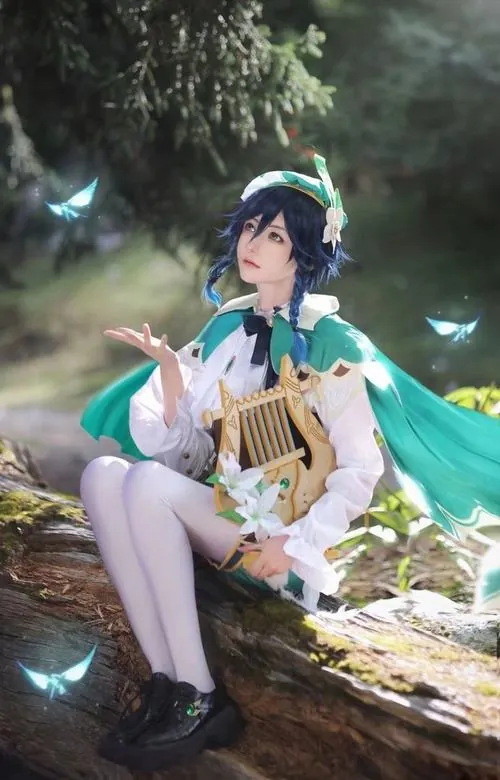 Nữ cosplayer đứng trong studio nền xanh đậm, biểu tượng nguyên tố phong phát sáng phía sau làm nổi bật đôi mắt màu ngọc