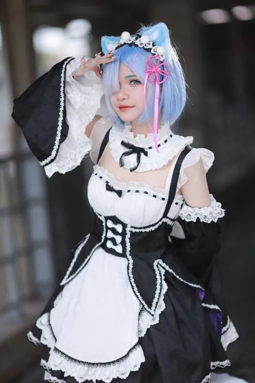 Bộ phụ kiện cosplay gồm bờm trắng, tất dài, nơ đen và găng tay ren được xếp gọn trên nền vải xanh.