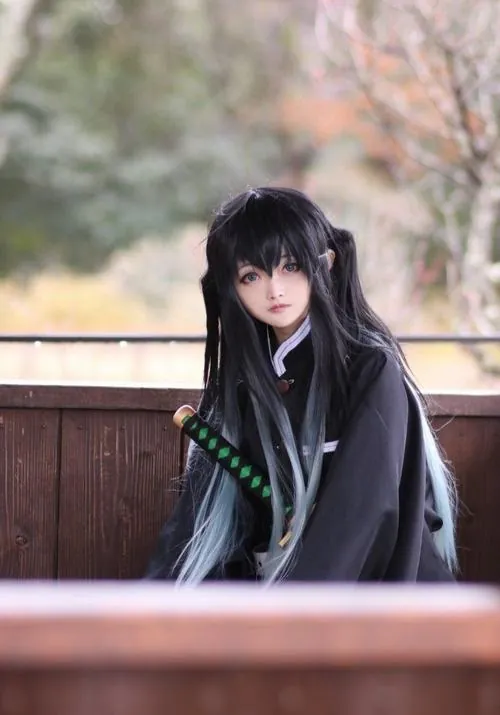 Nữ cosplayer nâng kiếm ngang vai, dáng đứng thẳng, ánh mắt bình tĩnh và lớp trang điểm làm đường nét khuôn mặt rõ hơn